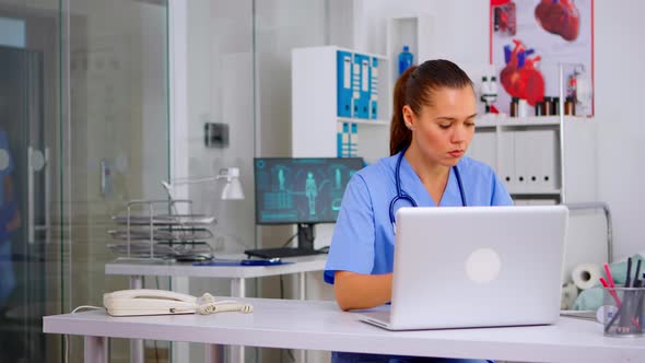 Medical Woman Nurse Holding Patient Radiography Typing on Laptop