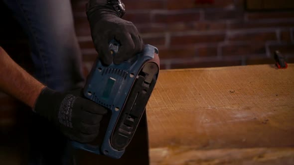 Side View of Polishing Wooden Edges with Grinder in Workers Hands