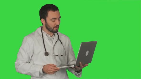 Doctor Having Video Conference on Laptop With Patient on a Green Screen, Chroma Key