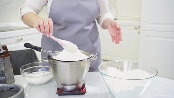 Cook Sifts the Flour Through a Sieve to Prepare Dough in a Mixer Bowl on Scale