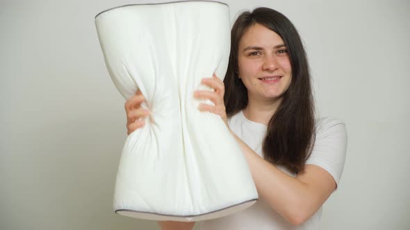 A Woman Compresses an Orthopedic Pillow the Pillow Takes Its Former Shape