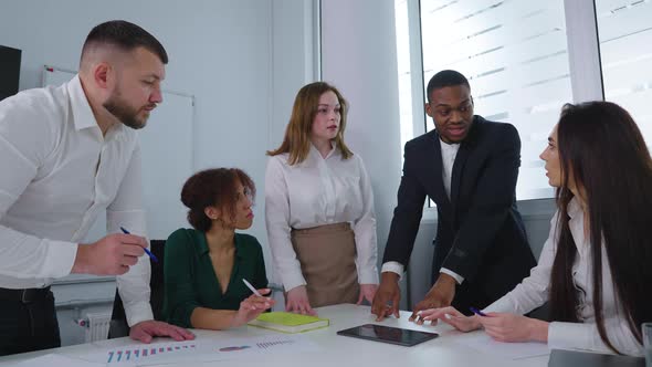 Black Boss Talking to Diverse Staff at Meeting