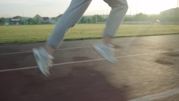 Young Beautiful Girl in Sweatpants and an Orange Tshirt Goes in for Sports