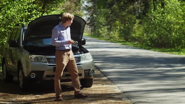 Man Standing Near Breakdown Car Using Smartphone Waiting for Service