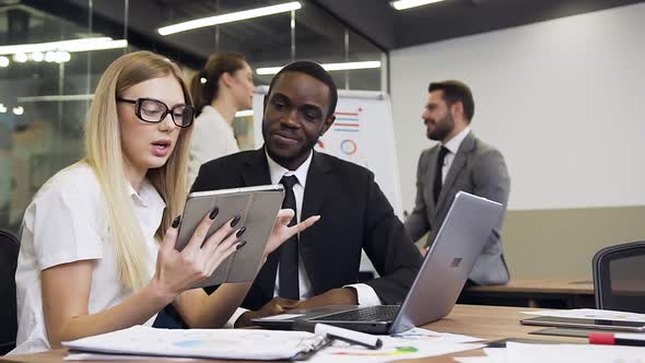 Business Partners which Working at the Boardroom Table Under Joint Project Using Tablet PC