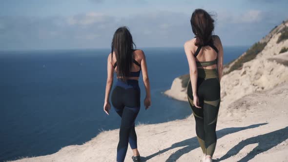 Rear View of Young Sportswomen Comes to the Edge of Cliff
