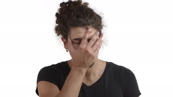 Closeup of Annoyed and Tired Hispanic Bearded Man with Curly Hairstyle Making Facepalm Then Looking