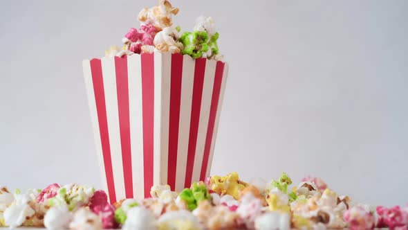 Popcorn Spilling From a Paper Container on Wooden Background