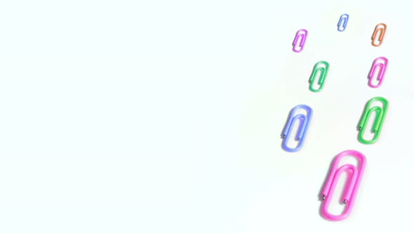 Colorful Paper Clips Spin on White Background