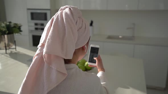 A Young Woman Watching your Smartphone at Home