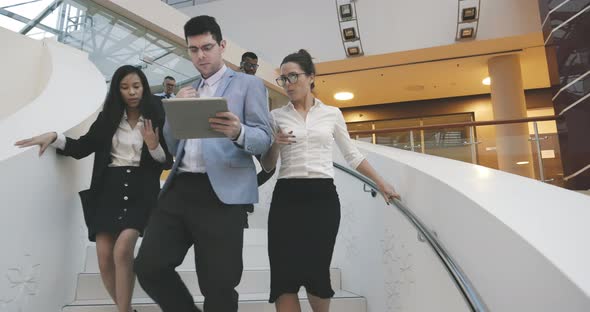 Business People Walking Downstairs in Modern Office