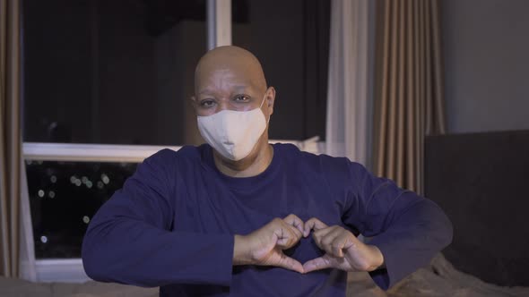 Portrait of ill old black american man, African person wearing a face mask for corona virus