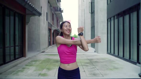 young Asian women legs and stretching her arms to ready for running on street in urban city park.