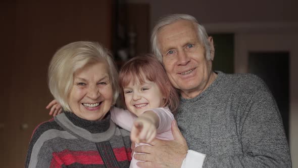 Smiling Family Grandfather, Grandmother with Child Granddaughter at Home