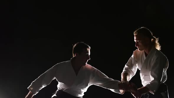 Two Fighters Participants of the Training in Special Clothes of Aikido Hakama Work Out the Methods