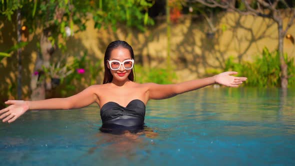 Young asian woman enjoy around outdoor swimming pool for leisure