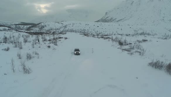 Car Driving through the Field in Winter