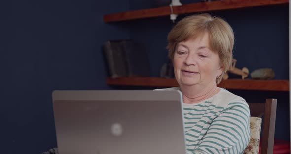 An Elderly Woman is Talking Via Video Communication Via a Laptop