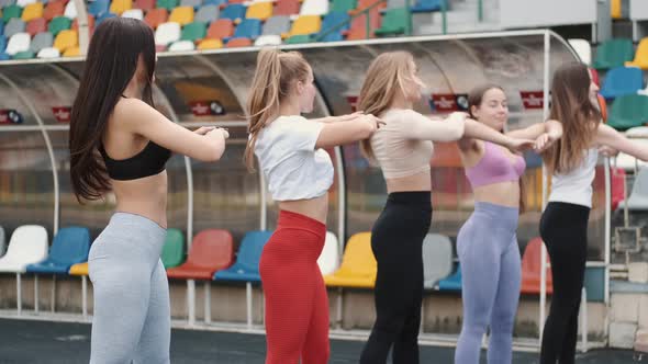 Five Pretty Sporty Girls Doing Warming Up Before Workout on Stadium