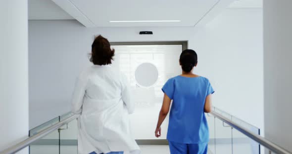 Doctor and nurse running in passageway of hospital