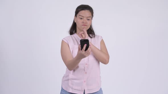 Young Happy Asian Businesswoman Thinking While Using Phone