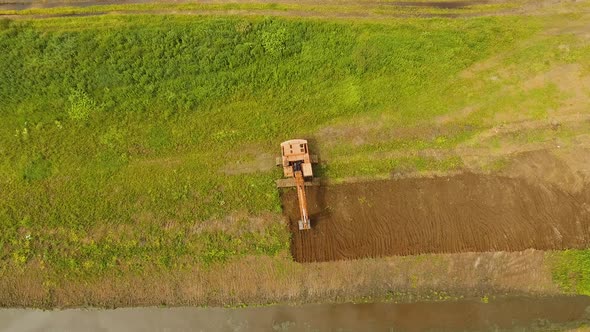 Excavator Digging a Trench in the Field