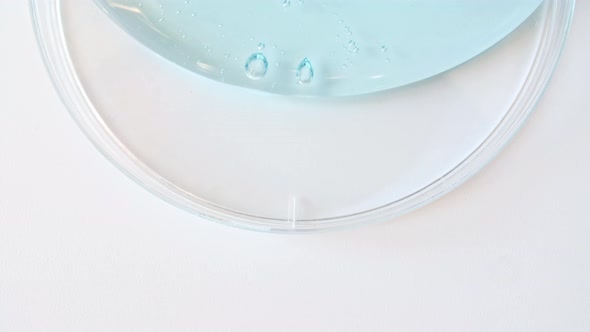 Blue Transparent Cosmetic Gel Cream With Molecule Bubbles Flowing On The Plain White Surface