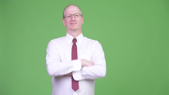 Mature Bald Businessman with Arms Crossed