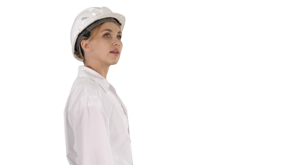 Young Woman in Hard Hat Walking and Looking Around on White