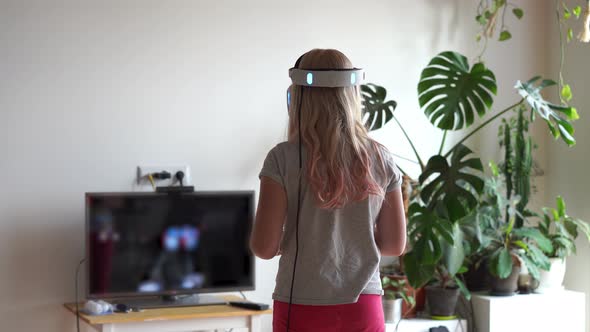 Modern Life of Youth. The Latest Electronic Technology in Everyday Life. Teenage Girl Plays at Home