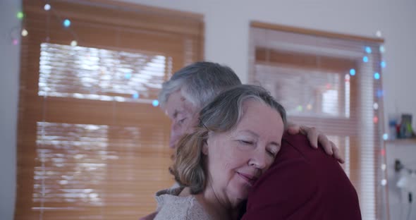 an Elderly Married Couple Cuddle in Their Home Bringing Peace and Love to Each Other