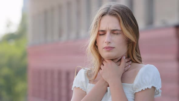 Young Adult Woman Suddenly Feels Sore Throat Holds Neck with Hands Swallows Closes Eyes