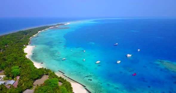 Natural above island view of a summer white paradise sand beach and blue sea background in 4K