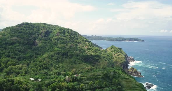 Aerial view showing plantation growing on green hill along coastline of YOGYAKARTA, INDONESIA