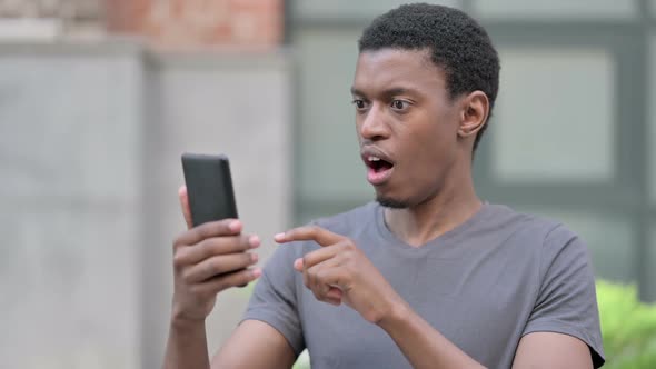 Portrait of Upset Young African Man Having Loss on Smartphone