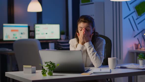 Stressed Businesswoman Suffering From Headache at Work Doing Overtime