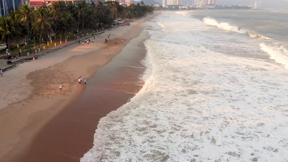 People Play Football on the City Beach and Beautiful Running Waves of Sea Waves Crash on the Sandy