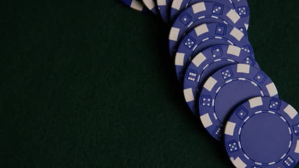 Rotating shot of poker cards and poker chips on a green felt surface - POKER 051