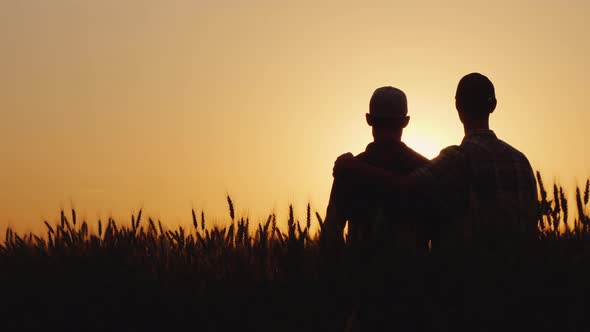 Two Gay Men Stand Hugging at Sunset