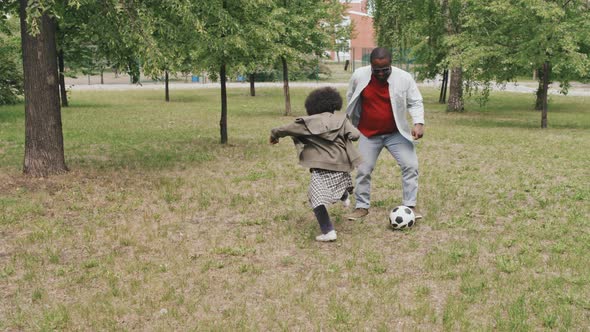 Father and Son Playing Football Outdoors