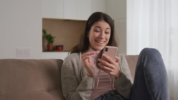 Young Adult Woman Browsing the Web on Her Smart Phone and Show a Variety of Reactions on the Content