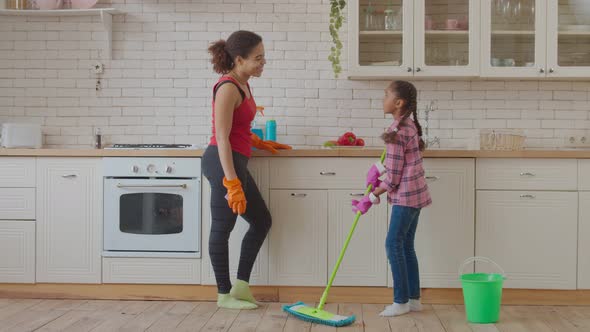Little Girl Washing Floor with Mop in Kitchen