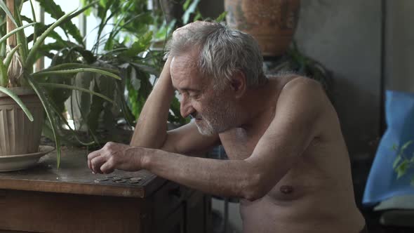 Man Counting Coins on a Table