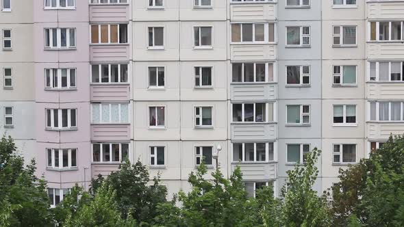 Windows Of A Multi Storey Panel Building. At The Bottom Of The Frame, The Tops Of The Trees
