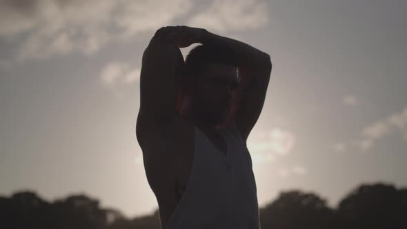 Young Attractive Man Stretching In Park Before He Works Out - Ungraded