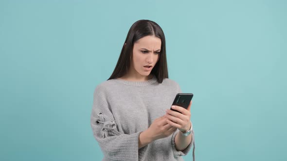 Portrait of a Surprised Confused Woman Looking at Mobile Phone