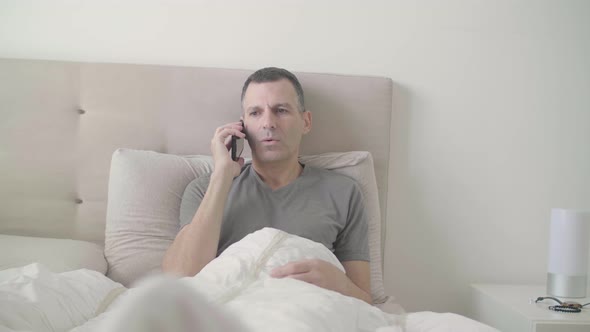 Man on His Phone While in Bed