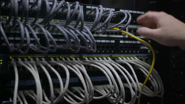 an IT Engineer's Hand Plug Out the Network Cable From the Network Switch