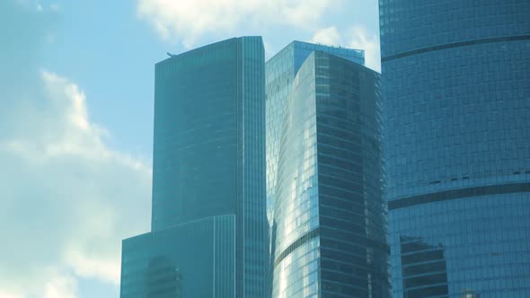 Modern office buildings on background of running clouds. Skyscrapers