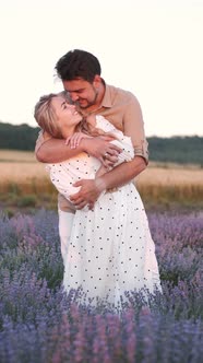 Loving Young Couple Standing in the Lavender Field and Hugging